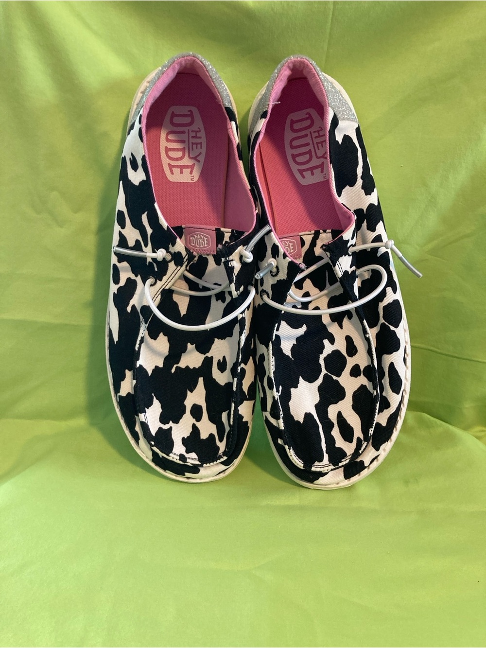 Hey Dude women’sCow-Print Slip-On Sneakers in Black & White with Pink Lining